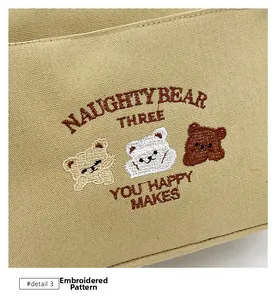 Close-up of three cute embroidered bears and text detail on khaki canvas tote bag