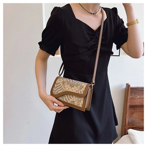 Chic retro crossbody bag with vintage floral pattern worn by a model in a black dress