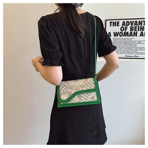 Model wearing retro green crossbody bag with wave pattern over a simple outfit