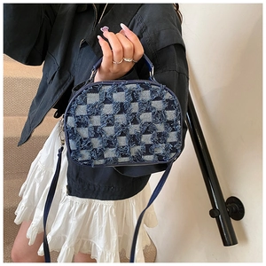 Dettaglio mini borsa a scacchi in denim blu con bordi sfrangiati e tracolla moda