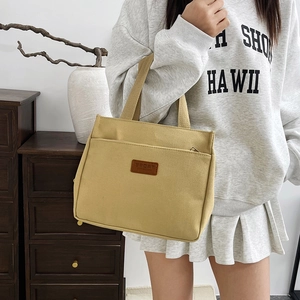 Minimalist yellow canvas tote bag with sport patch and front pocket for daily use