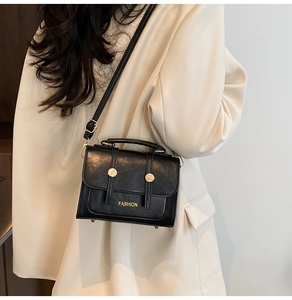 Detailed macro view of black faux leather texture and gold hardware on a vintage handbag