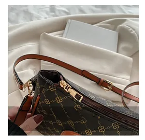Detailed shot of smooth metal zipper and gold hardware on brown checkered shoulder bag