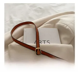Detail shot of the adjustable brown leather strap with polished gold metal buckle