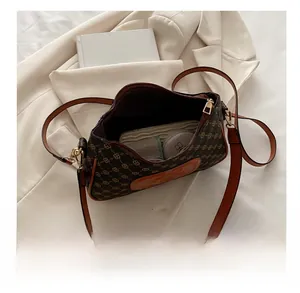Interior capacity of vintage brown monogram underarm bag holding makeup and wallet