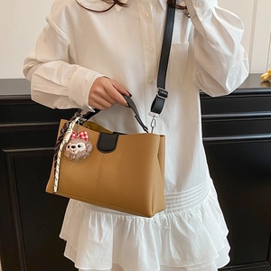 Sac à main marron en cuir grainé avec pendentif ours et bandoulière noire réglable