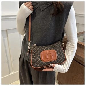 Detail of vintage brown crossbody bag with chain pattern and G logo leather patch