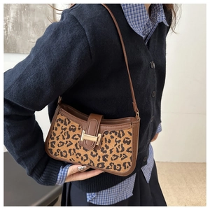 Vue détaillée de la texture léopard et de la boucle vintage sur le sac porté épaule