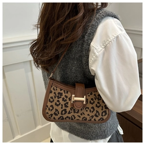 Détail du sac léopard vintage avec bordure en cuir marron et boucle dorée chic