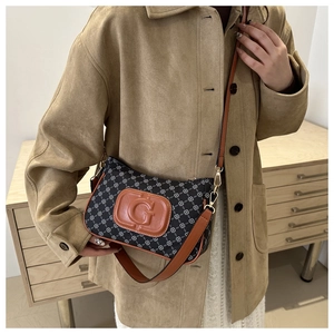 Detailopname van vintage canvas crossbodytas met geometrische patronen en leren G-patch