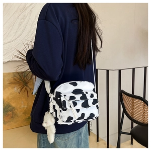 Detail of checkered nylon crossbody bag with plush bear charm and adjustable strap