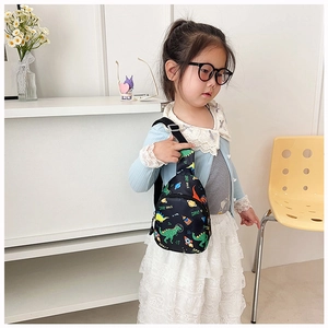 Detail of dinosaur print child chest bag with adjustable strap and space theme pattern