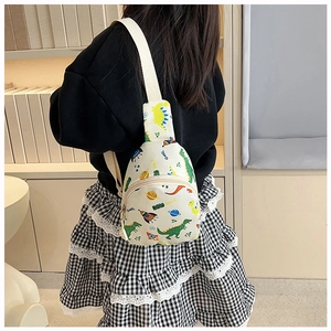 Close-up of kids dinosaur chest bag with space patterns and adjustable white strap