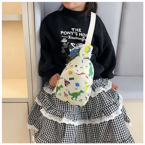 Toddler wearing a white dinosaur and space print crossbody bag with cartoon patterns