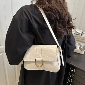 Sac baguette blanc à motif crocodile avec boucle dorée porté à l'épaule pour femme