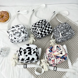Checkerboard and floral nylon crossbody bags with bear charms in a flat lay setup