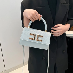 Fashionable ice blue crossbody bag with glitter texture and gold metal clasp on model