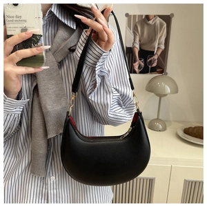 Chic black crescent underarm bag with lychee grain texture and vibrant red lining