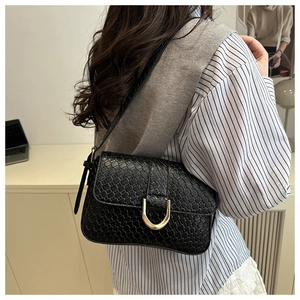 Détail du sac en similicuir crocodile noir brillant avec fermoir fer à cheval doré