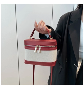 Detail of red and white contrasting linen bucket bag with premium leather stitching