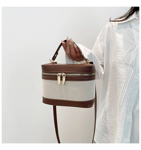 Detail of vintage bucket bag with contrast stitching and golden dual metal zippers