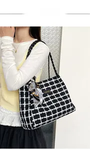 Close-up of black and white plaid tweed tote bag with silk scarf and woven straps