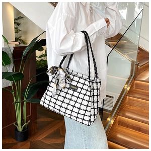 Close-up of black and white checkered tweed tote bag featuring decorative silk scarf