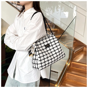 Detail of checkered canvas tote bag featuring floral scarf and fashion tag