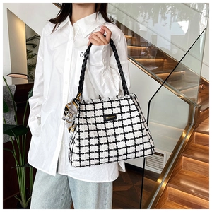 Detail of checkered canvas tote bag with woven handles and decorative silk scarf