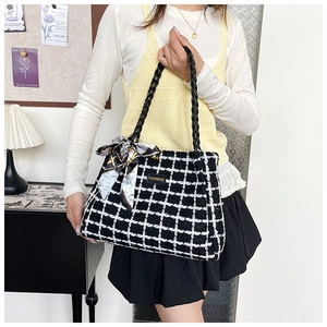 Detail of checkered canvas tote bag with fashion tag and silk ribbon accessory