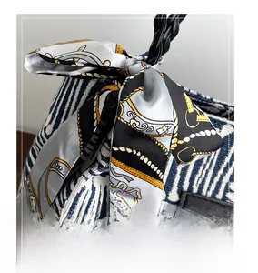 Detail of blue striped canvas bag with vintage printed silk scarf and leather handle