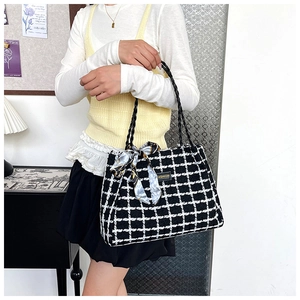 Detailed shot of black and white plaid canvas tote with woven handles and silk scarf