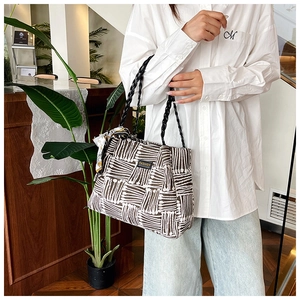 Fashion tote bag with brown stripes and decorative silk scarf shown on person