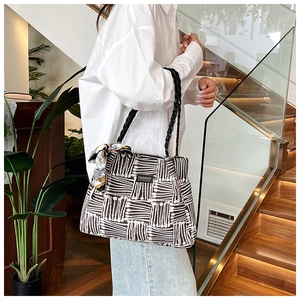 Detail view of canvas tote bag with black and white geometric stripes and woven handles