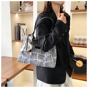 Detail of navy stripe tote bag with decorative silk scarf on a woven shoulder strap