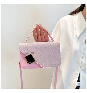 Detail of pink woven small square bag featuring sparkling rhinestone flap and golden buckle