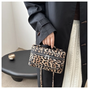 Detail der Handtasche mit Leopardenmuster, silbernem Reißverschluss und Strukturstoff
