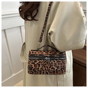 Detail der Box-Tasche mit Leopardenmuster, silbernen Reißverschlüssen und Schultergurt