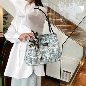 Fashionable striped tote bag with woven handles and silk scarf for women's commute