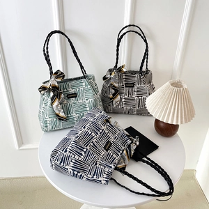 Three striped canvas tote bags in green, black, and blue with silk scarves and braided handles