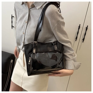 Detail of black PU leather tote bag with glossy pocket and adjustable shoulder strap