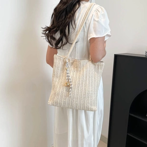 Sac fourre-tout élégant en paille tressée beige avec breloque et sangle texturée
