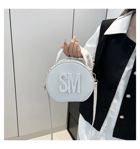 Detailed macro view of the round white crossbody bag with large metallic SM letter logo