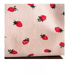 Detailed macro view of pink corduroy fabric featuring a cute red strawberry pattern