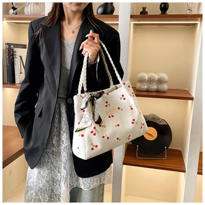 Detail of white tote bag featuring cherry embroidery and geometric print silk scarf