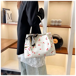 Detailed side view of large white corduroy tote bag with red cherry prints and scarf