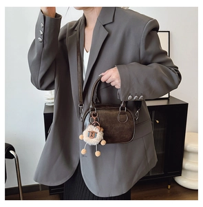 Détail du sac en cuir PU marron avec gaufrage Lucky No et breloque en peluche douce