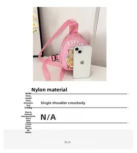 Rosa Nylon Capybara Umhängetasche neben einem Smartphone zum Größenvergleich