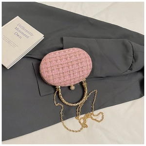 Detail of pink tweed evening clutch with gold metal frame and pearl diamond-studded clasp