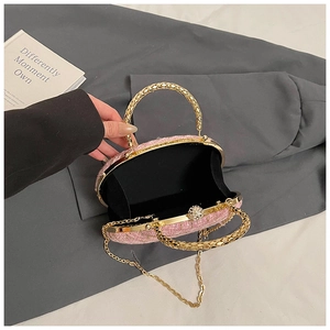 Detail view of pink tweed evening bag with gold metal handle and interior lining